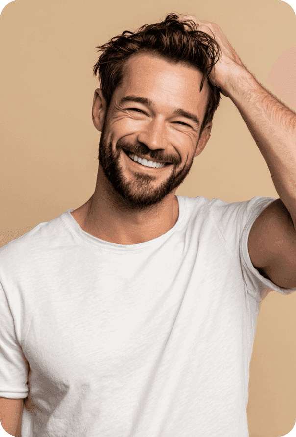 Smiling man running a hand through his hair